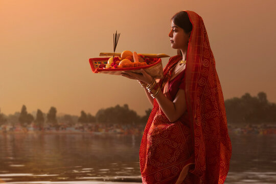woman from Bihar offers prayers to the  sun  in the  early morning hours   during  Chhath Puja festival