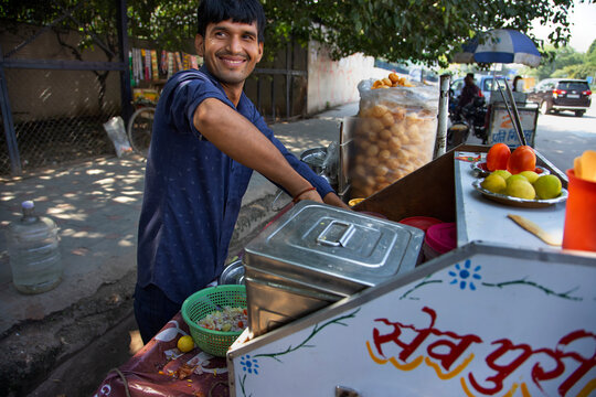 Portrait of a happy street vendor preparing ingredients at his stall