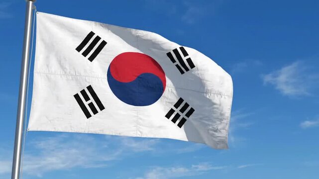 Realistic flag of South Korea waving against a blue sky with clouds