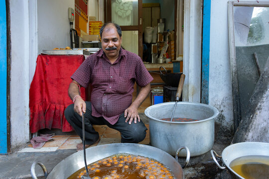 Owner of a sweet shop known as a Halwai  making Gulab jamun,a popular Indian snack in the  kitchen of his sweet   shop