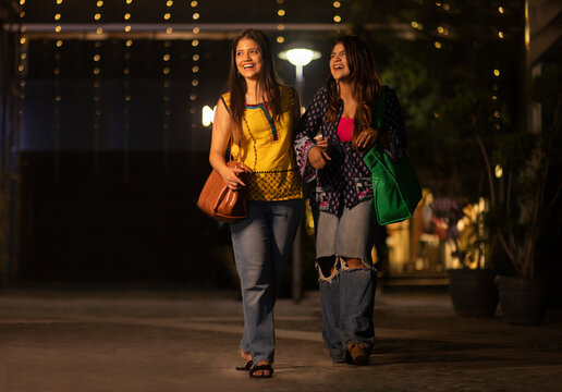 Portrait of two women with bags returning after shopping