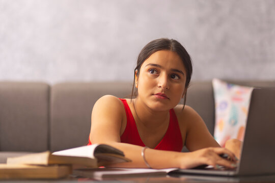 Portrait of a teenage girl doing homework during online classes