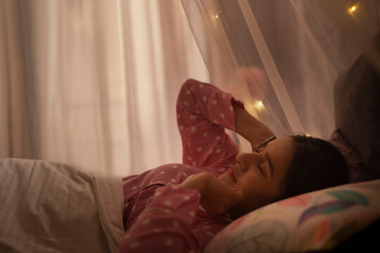 Beautiful teenage girl waking up after night sleep