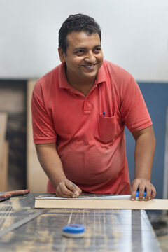 Male carpenter measuring the board
