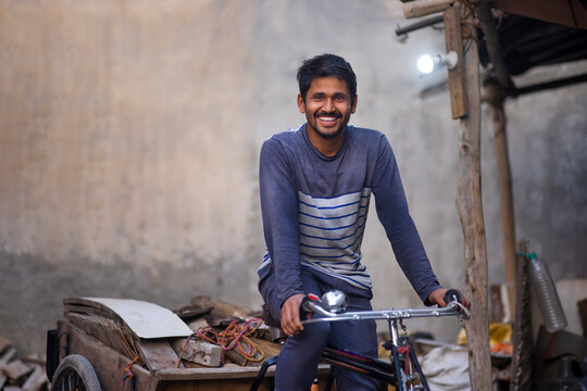 A Rickshaw puller taking away scrap