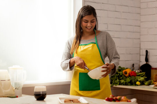 Portrait of smiling woman preparing for cookies in kitchen