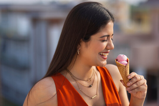 Close-up portrait of young woman eating ice cream in cone