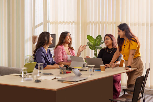 Group of businesswomen discussing a project at office workstation