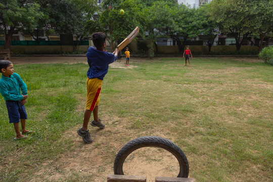 Portrait of boy hitting a shot while playing cricket in the park