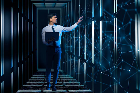 Technician/programmer holding a laptop in the server/data  room