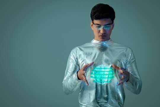A man wearing silver,futuristic  clothes holding digital globe ,future technology concept