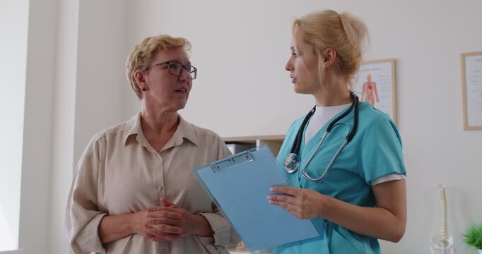 Doctor and nurse guide senior patient during consultation. In medical clinic, they discuss diagnosis, treatment options, and preventive healthcare services. Concept patient care and medicine.