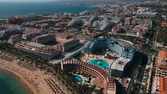 ocean shore with hotels and beach, Los Cristianos, luxury resorts and villas of Tenerife, Canary, aerial drone view 4k