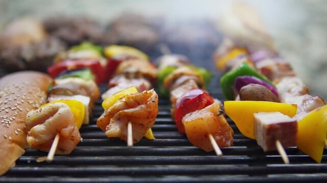Close-up shot of sizzling chicken and vegetable skewers grilling outdoors, captured with shallow depth and natural light for appetizing BBQ footage.