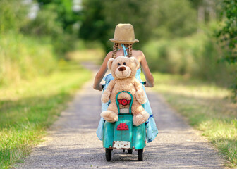 Happy Little Girl Riding a Vintage Scooter with Her Teddy Bear © Jenny Sturm