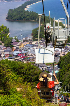 Tourist riding chairlift overlooking Amanohashidate sandbar in Kyoto, Japan