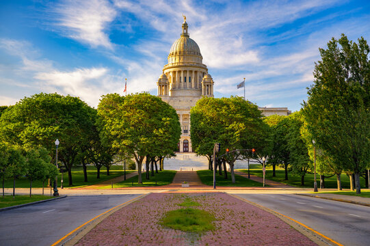 Marble Rhode Island State House in Providence, with its neoclassical dome and Independent Man statue glowing in warm evening light.