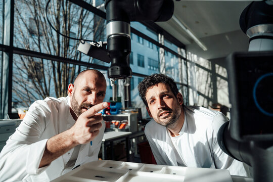 Scientist examining robot in modern laboratory