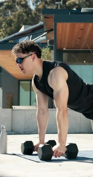 Dumbbells, fitness and push up with man outdoor for health, training or workout routine. Exercise, sunglasses and weightlifting with strong person on concrete porch of home for bodybuilding session