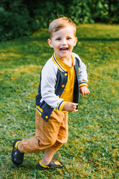 Laughing Little Boy Running across Sunny Green Lawn