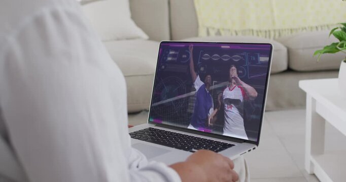 Woman holding laptop on sofa while onscreen soccer players jostling for lofted ball shifting grip