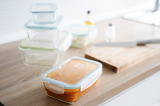 Glass meal prep containers with prepared food on kitchen table