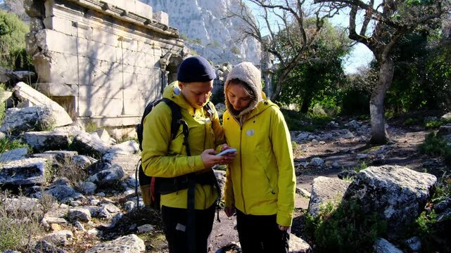 Young travelers discover ancient amphitheater and ruins of Termessos. Walking, climbing, enjoying view and ancient history in warm Turkish light.
