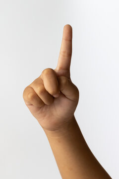 Child hand pointing finger up showing number one counting gesture