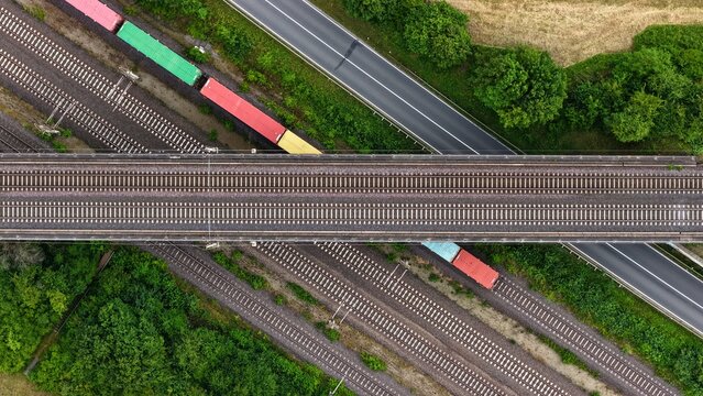 Top-Down Aerial View of Freight Rail Junction and Road Bridge