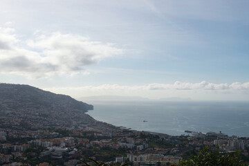 Spectacular panoramic view over Funchal with harbor, cruise ships and the Atlantic Ocean beneath dramatic clouds. © Eric