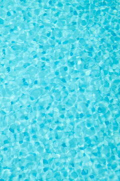 blue water in swimming pool with mosaic tiles and ripples surface background