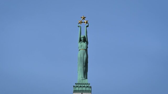 Freedom Monument statue holding three golden stars in Riga, Latvia
