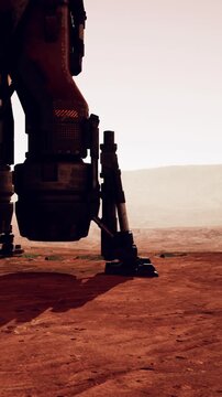 A large spaceship lander stands on the rocky surface of Mars. Its legs touch the ground as the morning sun casts long shadows. The landscape shows hills in the distance under a reddish sky.