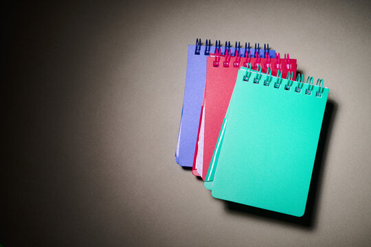Close-up of some small spiral notebooks on a desk.