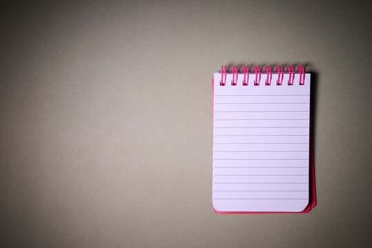 Closeup of a small spiral notebook open on a desk.
