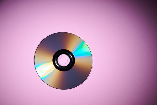 Close-up of a CD on a purple desktop.
