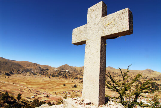 Bolivia, Copacabana, view of a cross representing the 12 stages of the cross built on the summit of Mount Calvario, with cityscape in distance