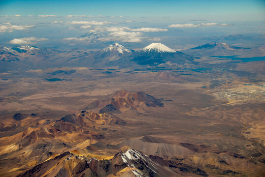 Bolivia, Chile, Inland, the Western Range or Cordillera Occidental, at the border between Bolivia and Chile, with volcanoes and high peaks with perennial snows against cloudy sky