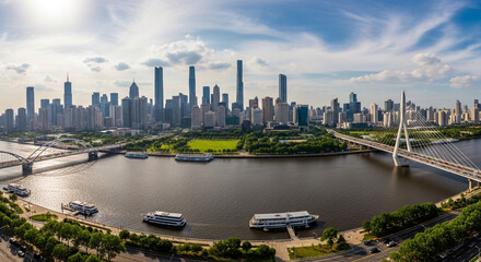 Fototapeta premium Panoramic aerial view of Guangzhou city skyline with Pearl River and modern bridges under a blue sky in China