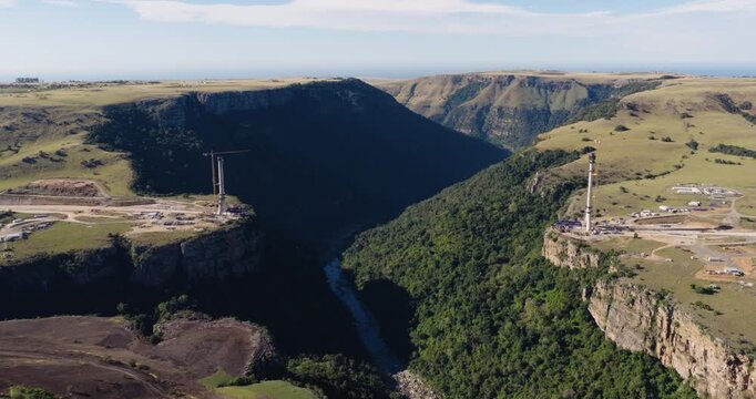 Panning wide aerial view of the construction of Msikaba Bridge in the Eastern Cape, South Africa. It will span 580 meters across the Msikaba River gorge and stand 194 meters high. Economic development