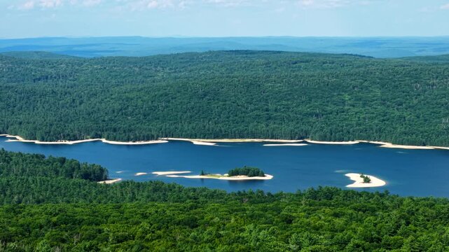 Low sandy islands in middle of Quabbin Reservoir Massachusetts on sunny summer day, drought levels drain and cause water scarcity issues