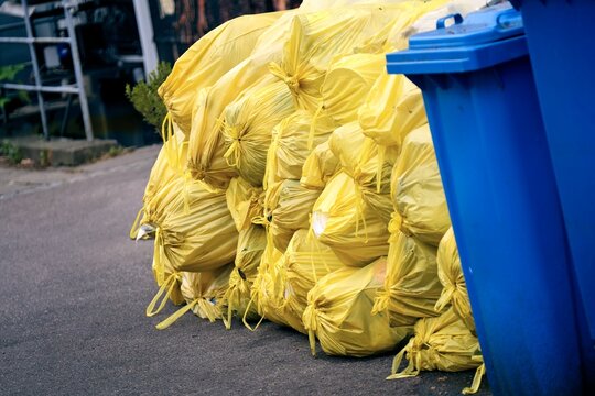 Yellow bags with plastic waste on the backyard. . Horizontal image.
