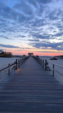 sunset over the pier with long wooden walkway