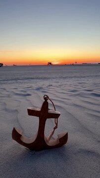 beautiful wooden anchor on the beach in sunset light	
