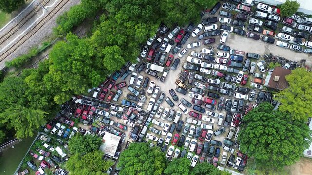 US Highway 175 commercial offshoots hide extensive industrial activity, salvage junkyard cars within thickets. Discarded passenger automobiles rest outside metal warehouses in Dallas, Texas