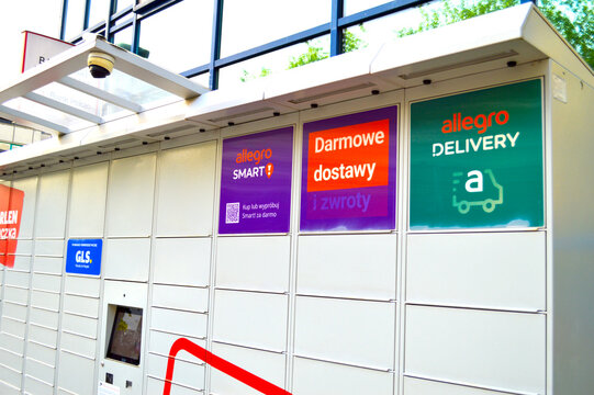 Modern automated parcel locker station for self-service package delivery and collection in Poland with Allegro and GLS branding under a bright outdoor canopy.