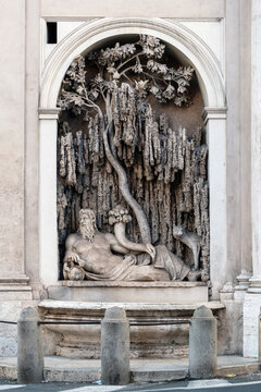 One of the historic Quattro Fontane baroque fountains in Rome, Italy, featuring the reclining river god Tiber with a she-wolf and a cornucopia inside a stone niche