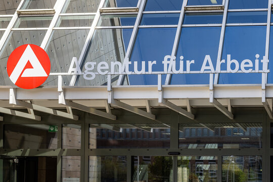 Eingangsbereich einer Agentur f&uuml;r Arbeit mit gut sichtbarem Schriftzug und dem markanten rot-wei&szlig;en Logo der Bundesagentur f&uuml;r Arbeit.