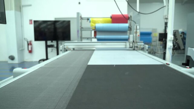 A large automated fabric cutting table in a clean industrial workshop