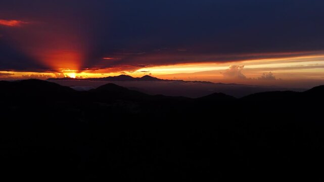 Cinematic aerial drone footage of a breathtaking sunset over the mountain landscape of Valle Nuevo National Park in Constanza, Dominican Republic.